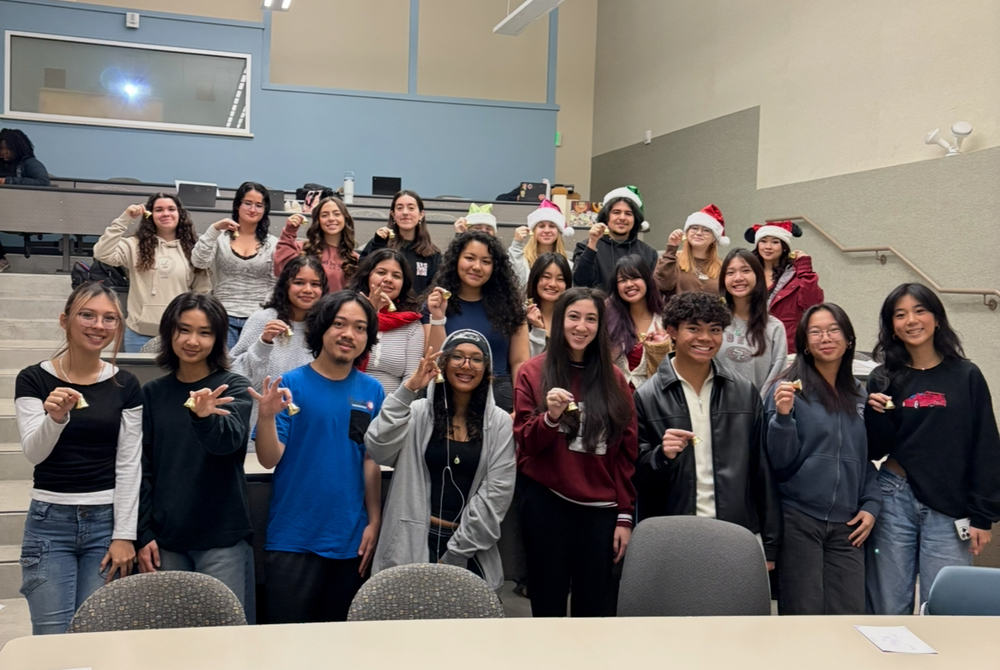 Early College High School Students pose for a photos with tiny bells in their hands because their school receives the CSBA Golden Bell Award for Excellence in Alternative Education
