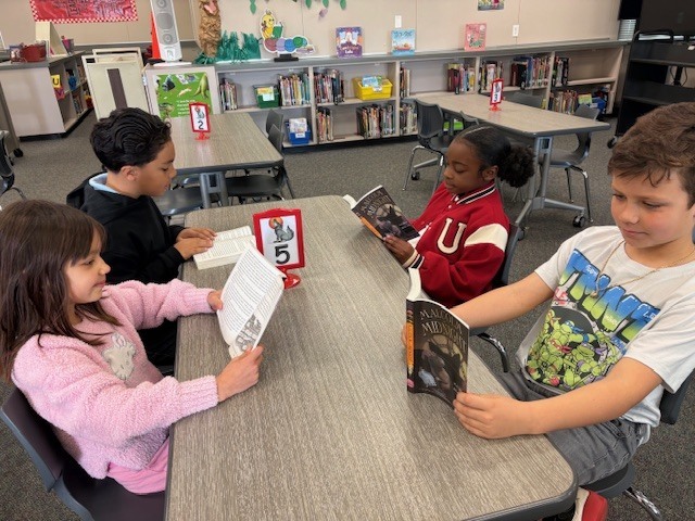 Kids sitting at a desk reading