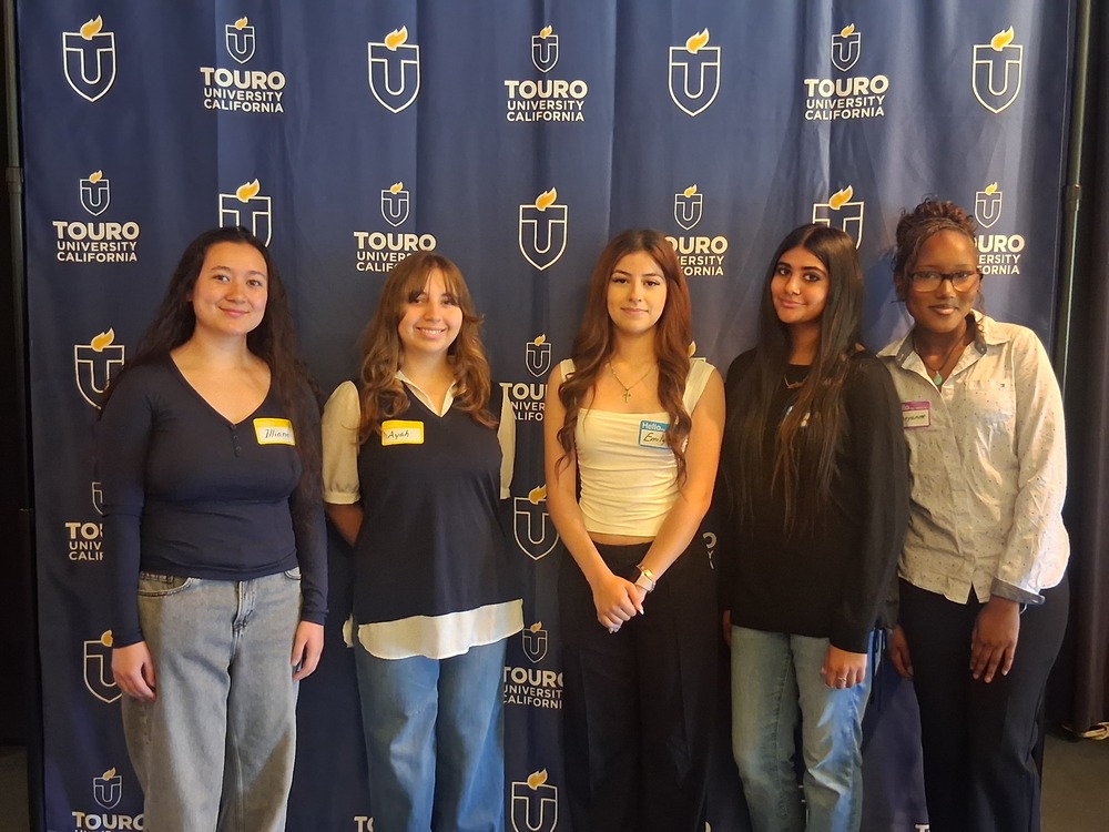5 FSUSD students posing in front of a Touro University backdrop