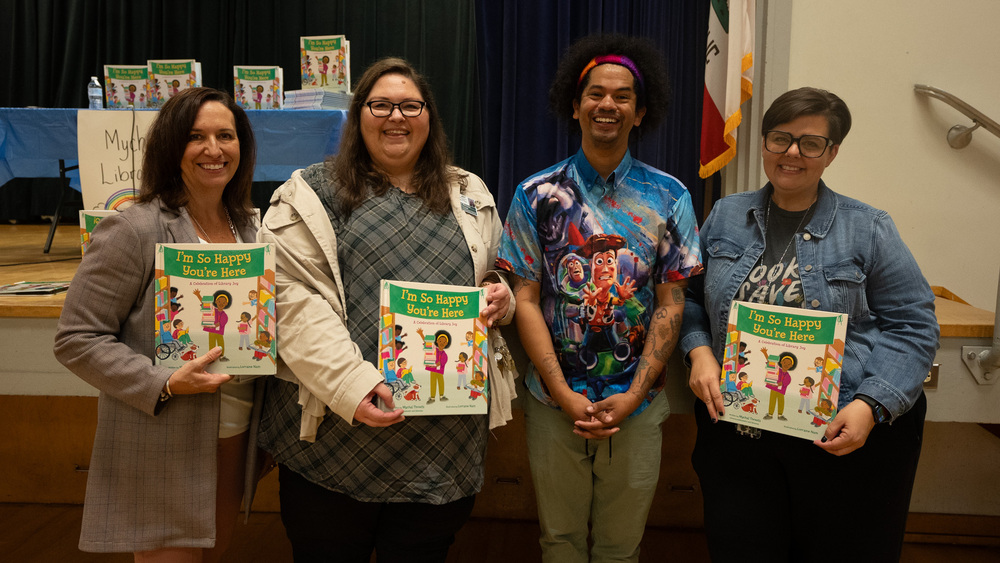 Superintendent and staff at Cleo Gordon pose for a picture with Reading Rainbow's Mychal Threets.