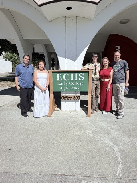 Group of ECHS student and staff posing in front of signs