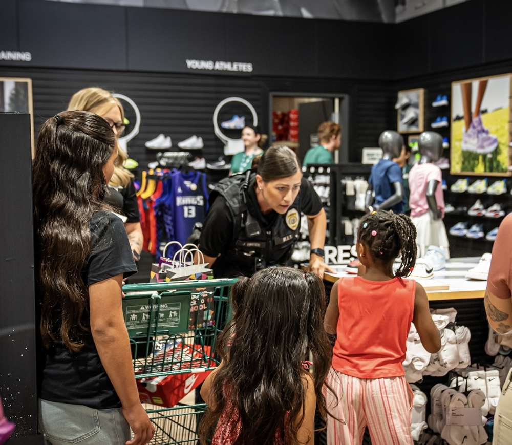 Police woman talking to children in Dicks Sporting Goods