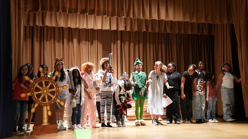 All students standing in a row as they bow to complete the "Peter Pan" production