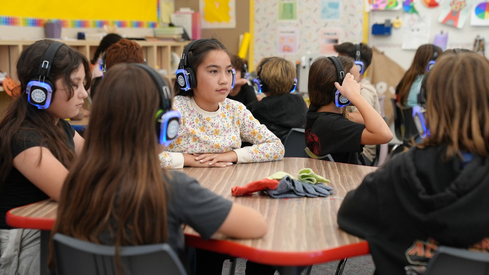Kids in class listening with Headphones made for students with disabilities.