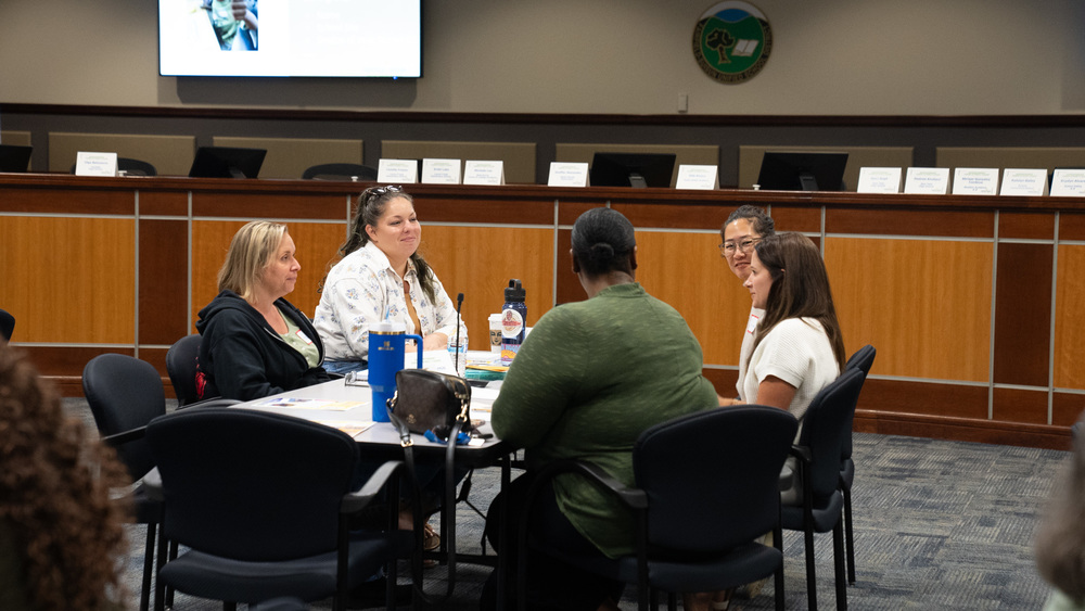 A group of parent leaders sitting at a conference table engaging