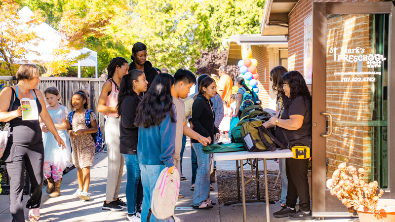 Students and families standing in lilne waiting for their Backpacks at the Back to School Resource Fair