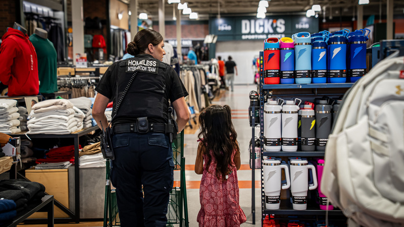 Police walking through dicks sporting goods shopping with a student