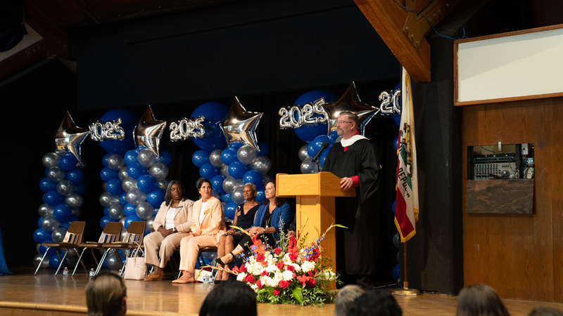 An admin preaching to an audience at a graduation