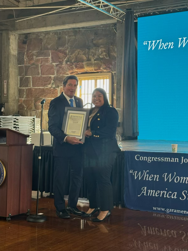 Marbeya Ellis and Congressman Garamendi taking a photo with award ion hand.