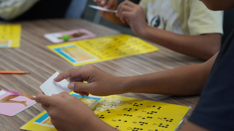 Students reading braille in class
