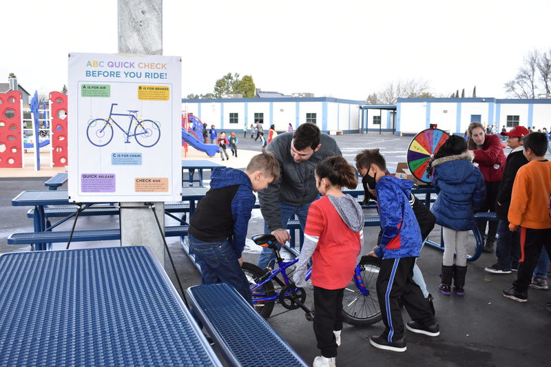 A teacher explaining to kids how to use a bike safely.