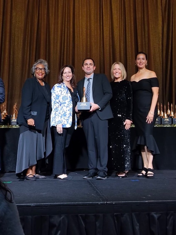 The Superintendent of FSUSD and the Principal John Pizzo of Early College High School stand on stage receiving award