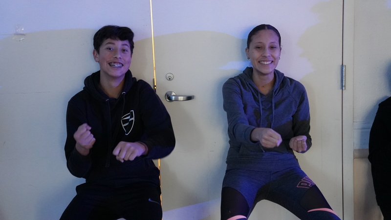 A virtual academy student andhis mother participating in the wall sits activity with Sami Circuit.