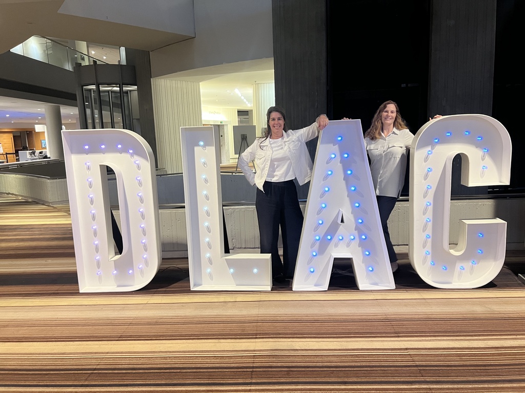 Photo of two people standing by DLAC sign