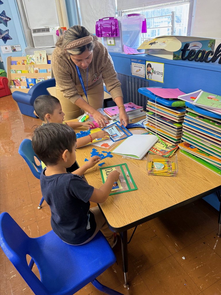 Mrs. Ospino helping students write their names during center time.