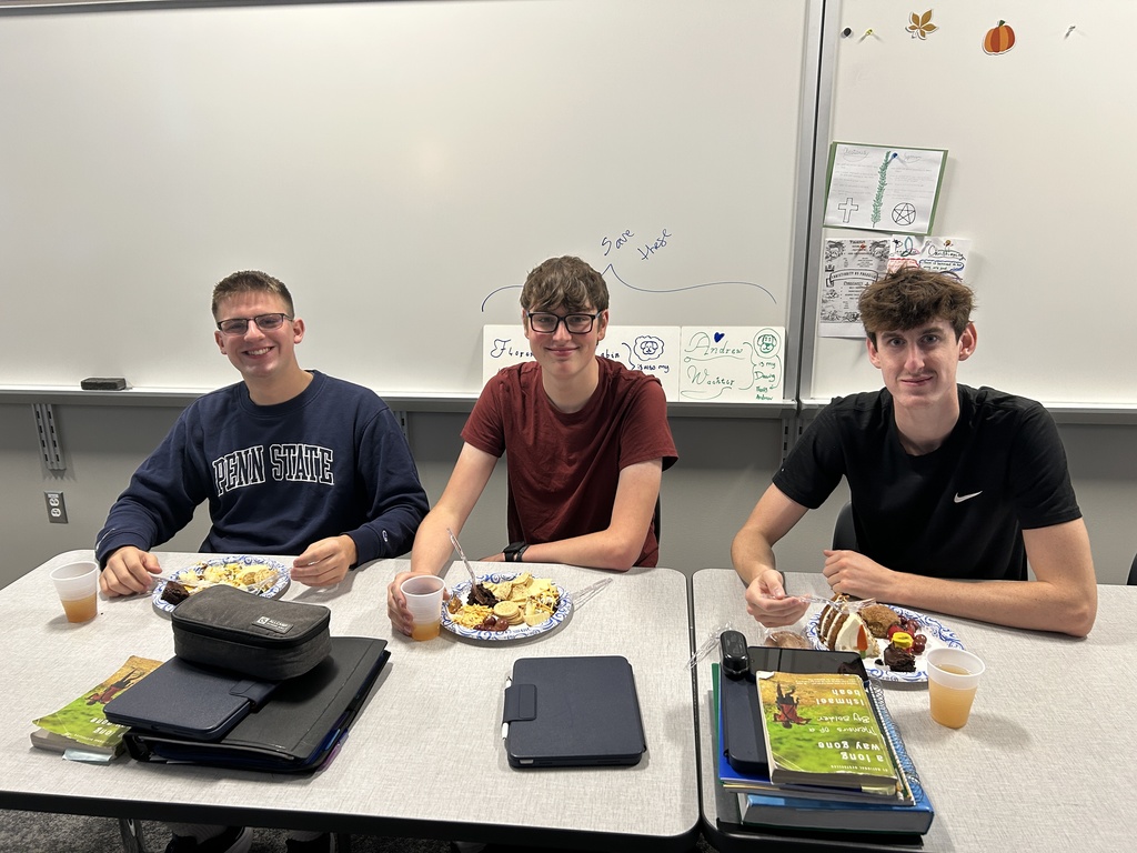 3 students smiling with plates of food.