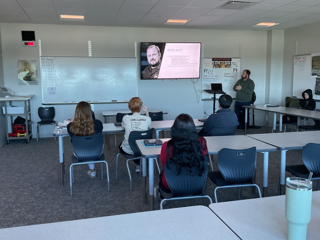 five students watching a presenter in class
