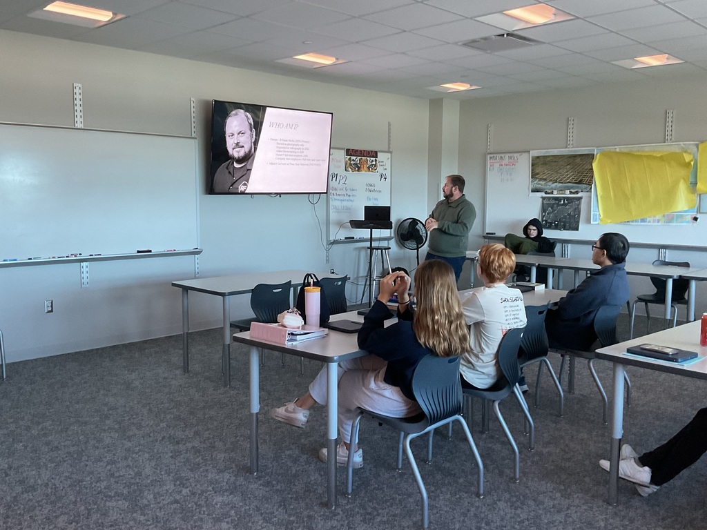 4 students watching a presenter in class