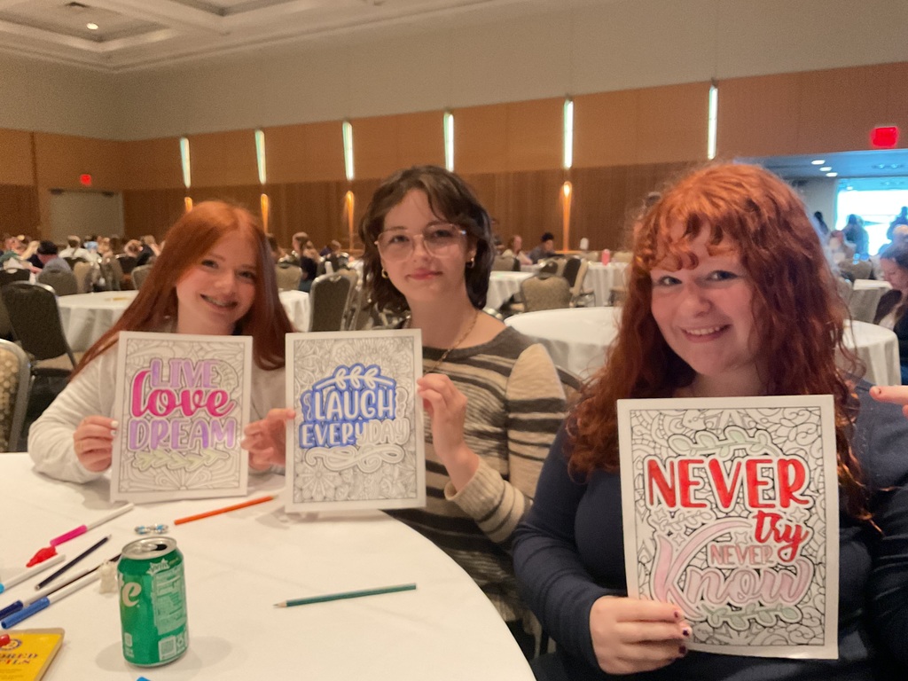 3 females holding signs they colored