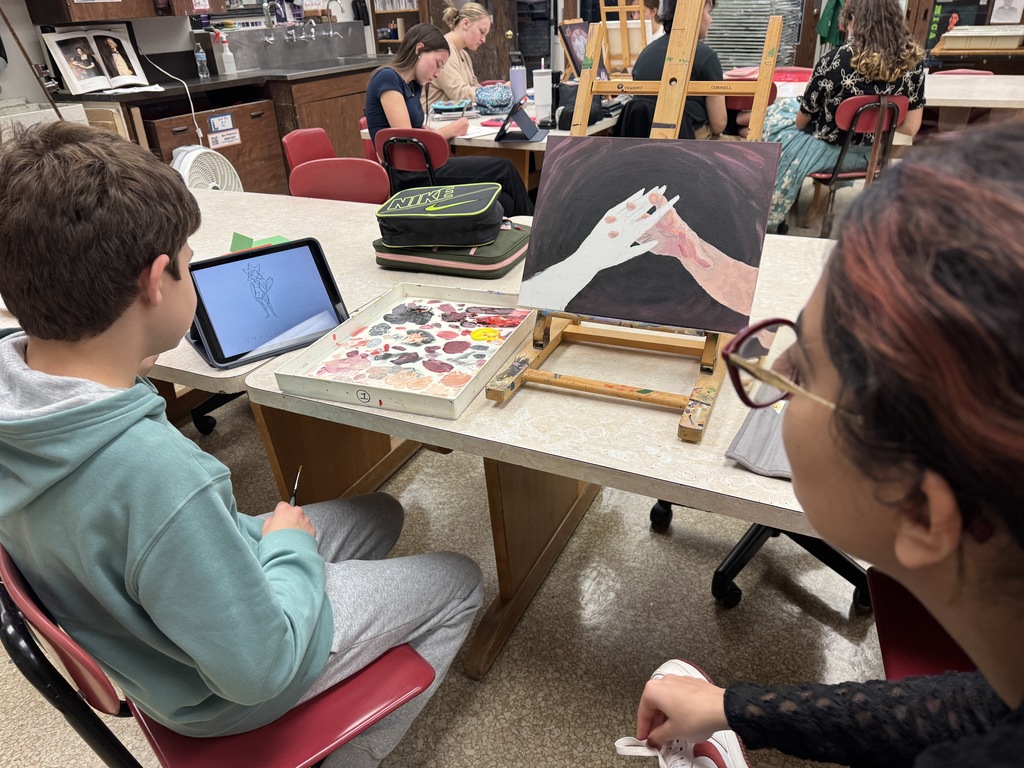 two students looking at a painting