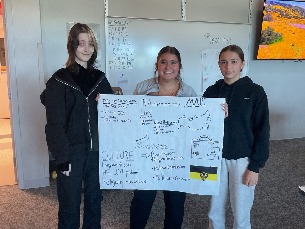 3 students holding a poster about Russia