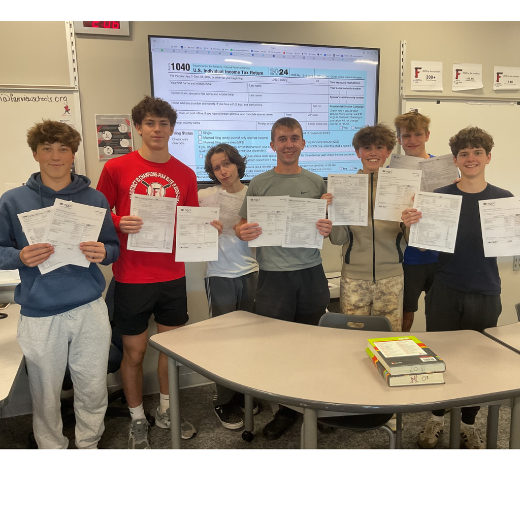 7 students holding tax forms that they filled out