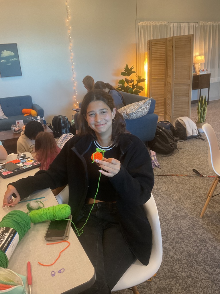 student holding a crochet pumpkin