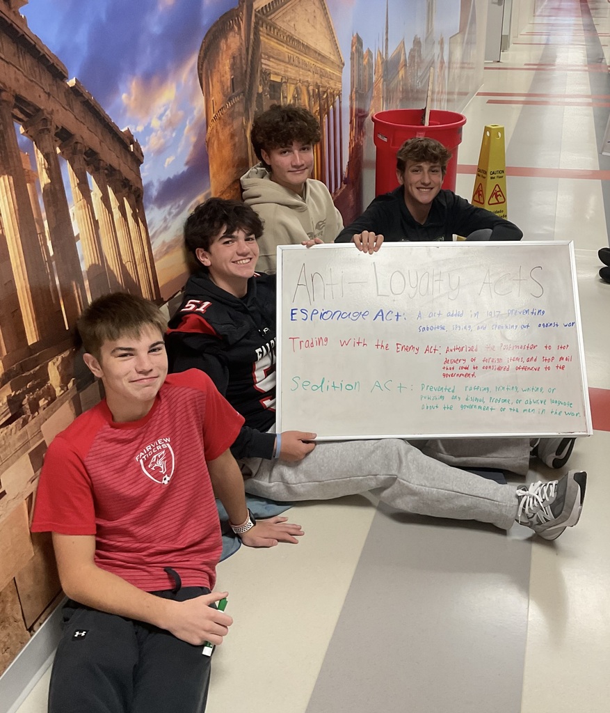 4 students holding a board about anti-loyalty acts