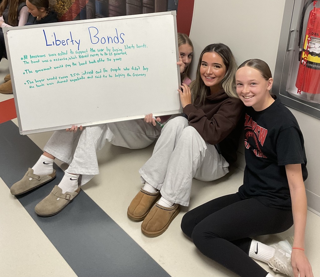 3 students holging a borad that says Liberty Bond