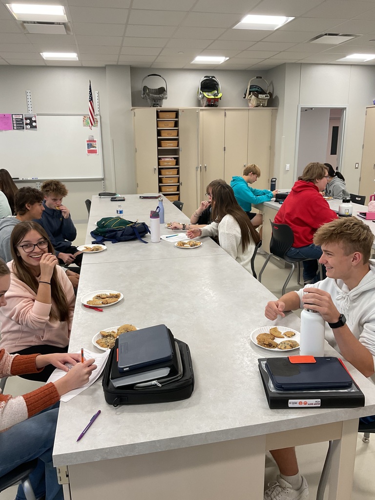 students sitting at tables trying cookies