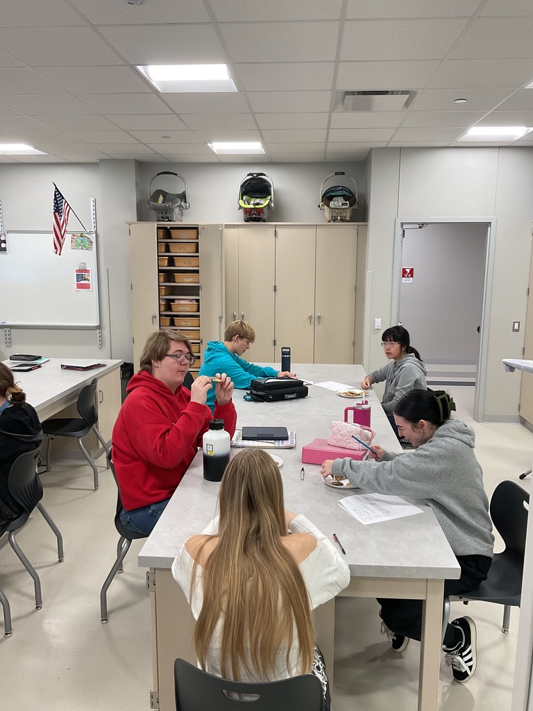students sitting at tables trying cookies