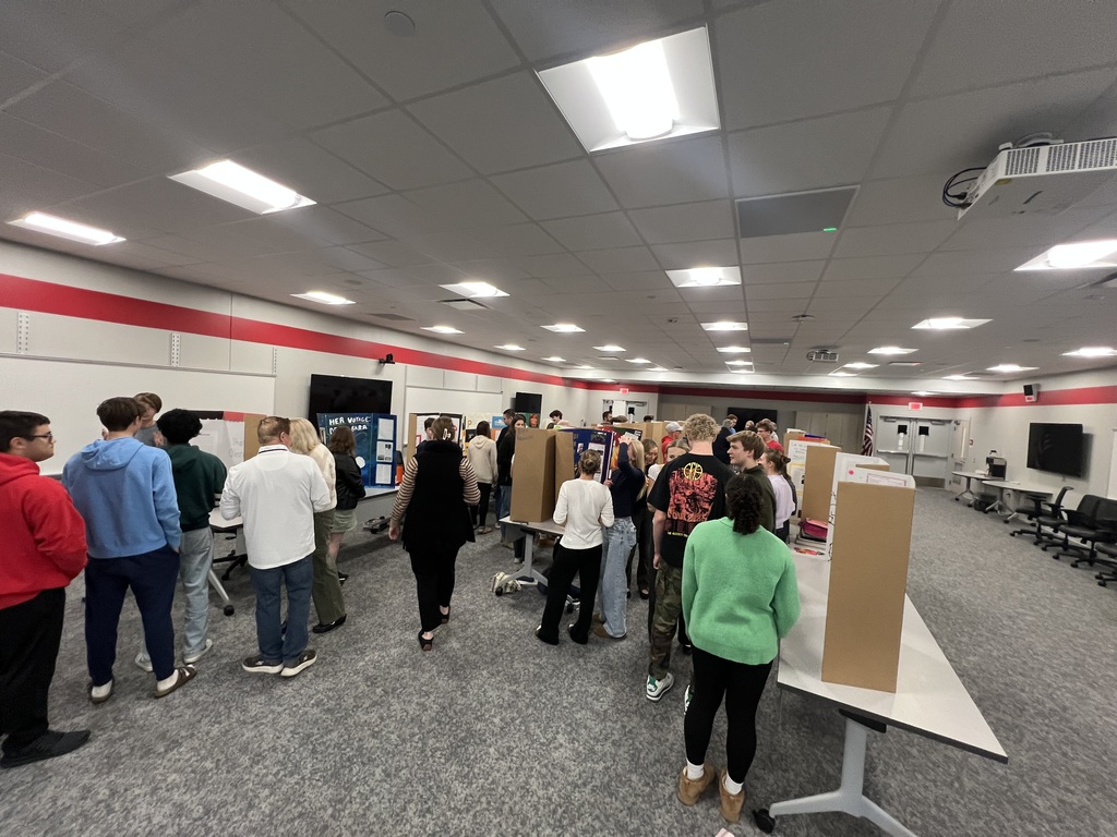 students and adults in front of display boards