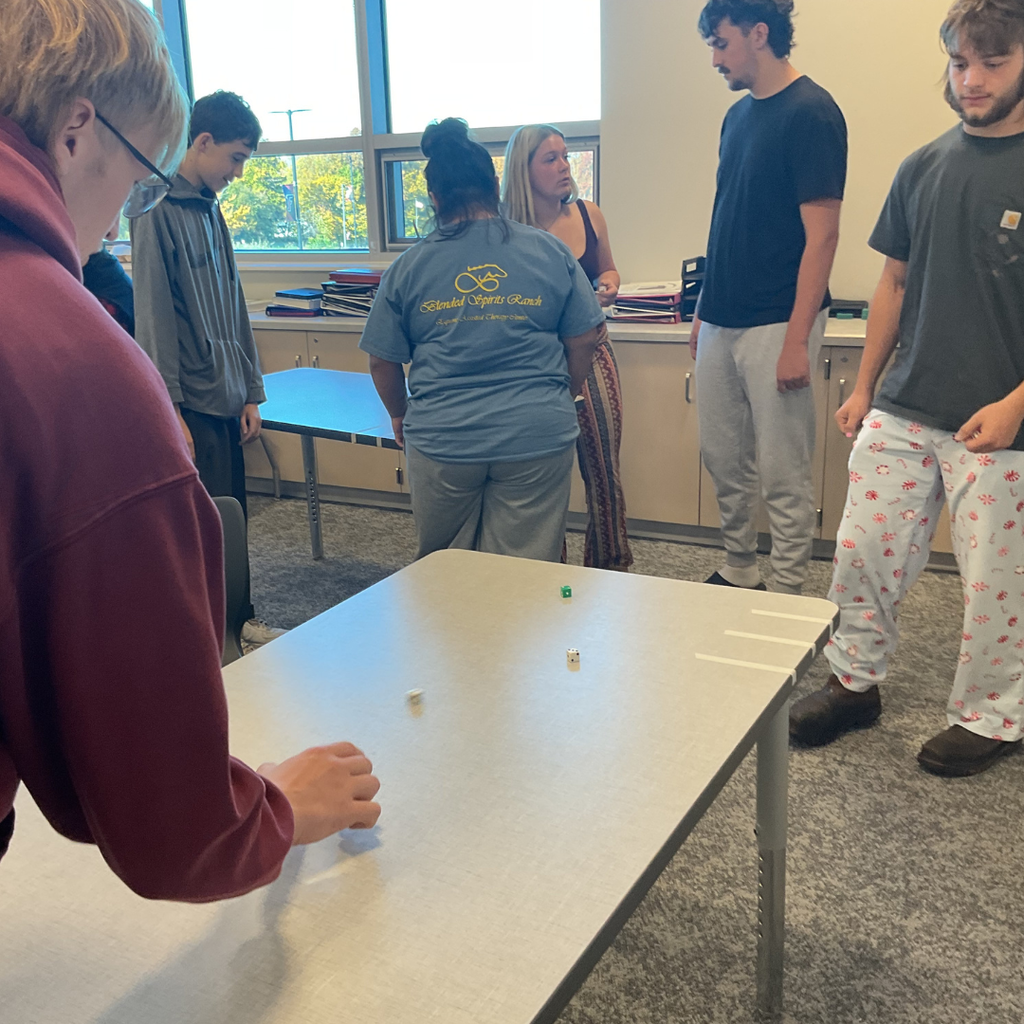 6 students playing a game called dice shuffleboard