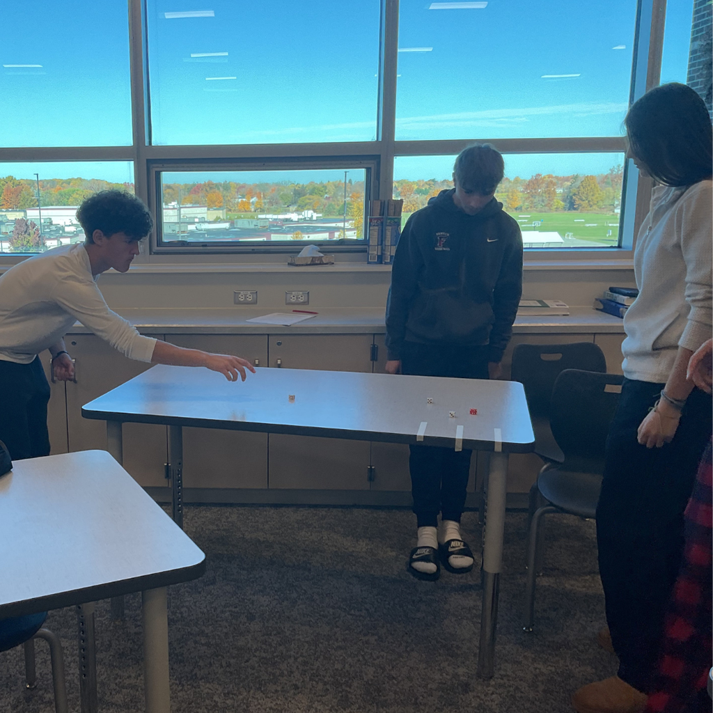 3 students playing a game called dice shuffleboard
