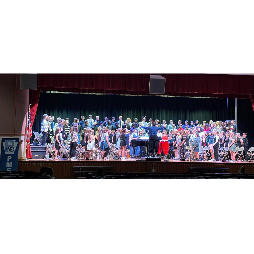 large group of students singing on stage