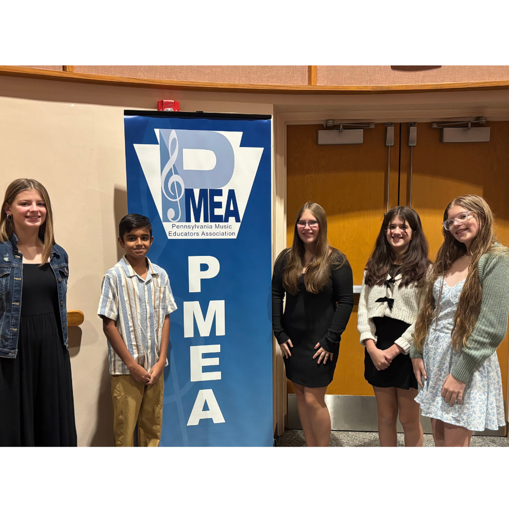 5 students standing by a PMEA banner