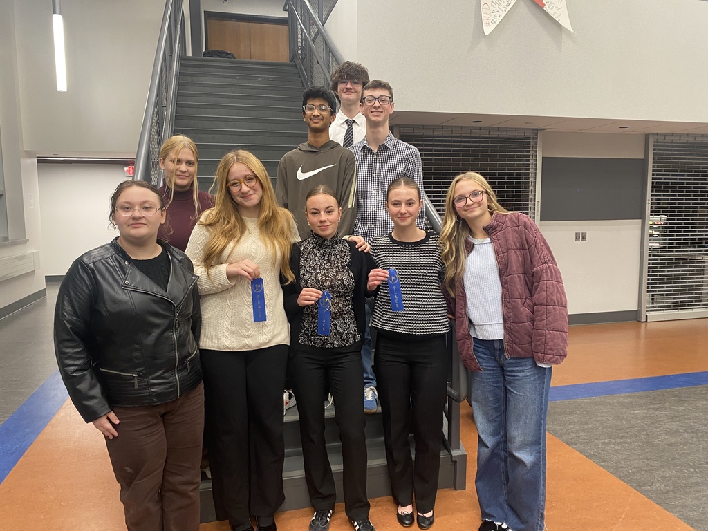 9 students standing holding ribbons