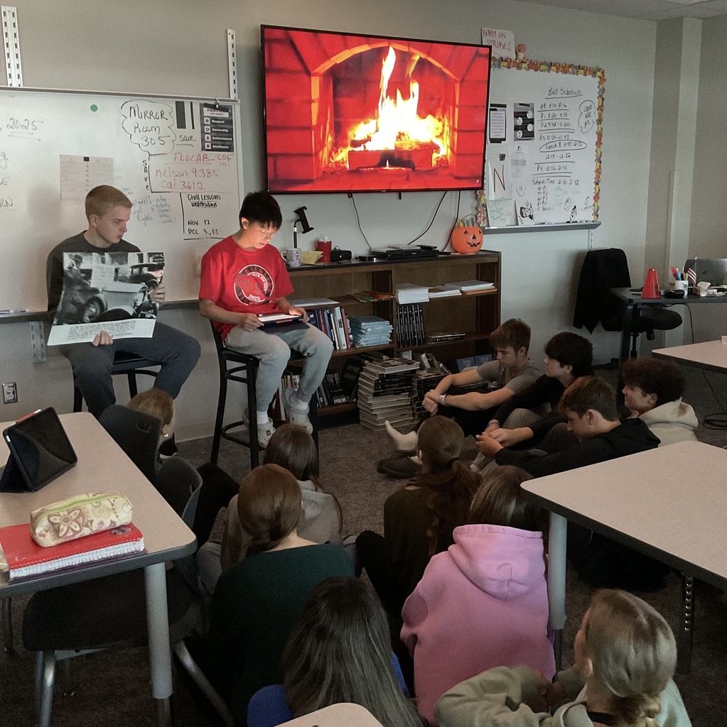 2 students presenting in front of a fireplace on a tv