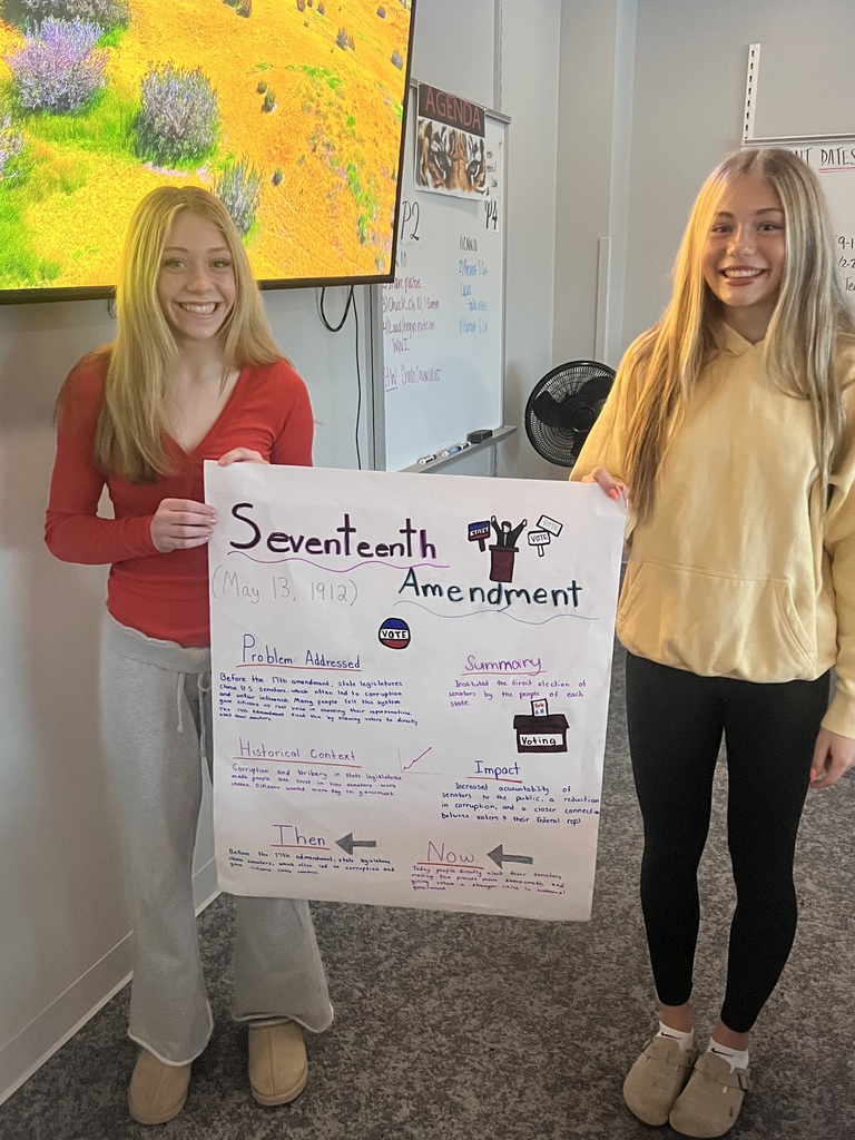2 students holding a poster