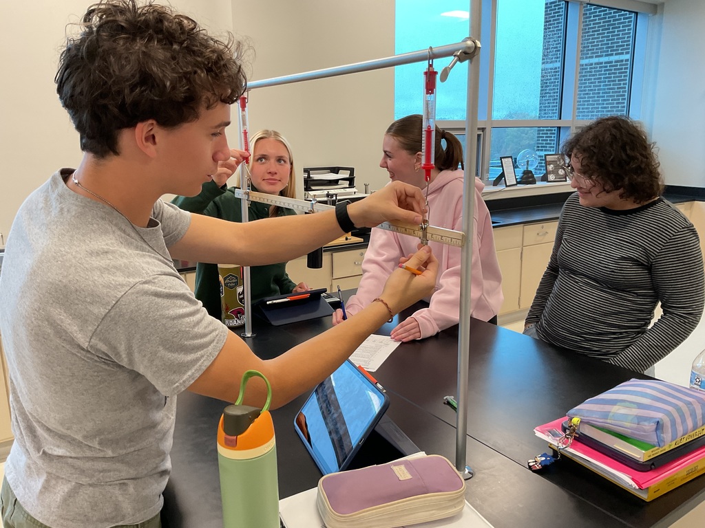 4 students looking on a ruler