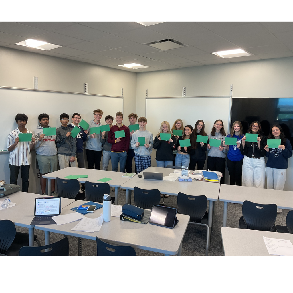 group of students holding green cards