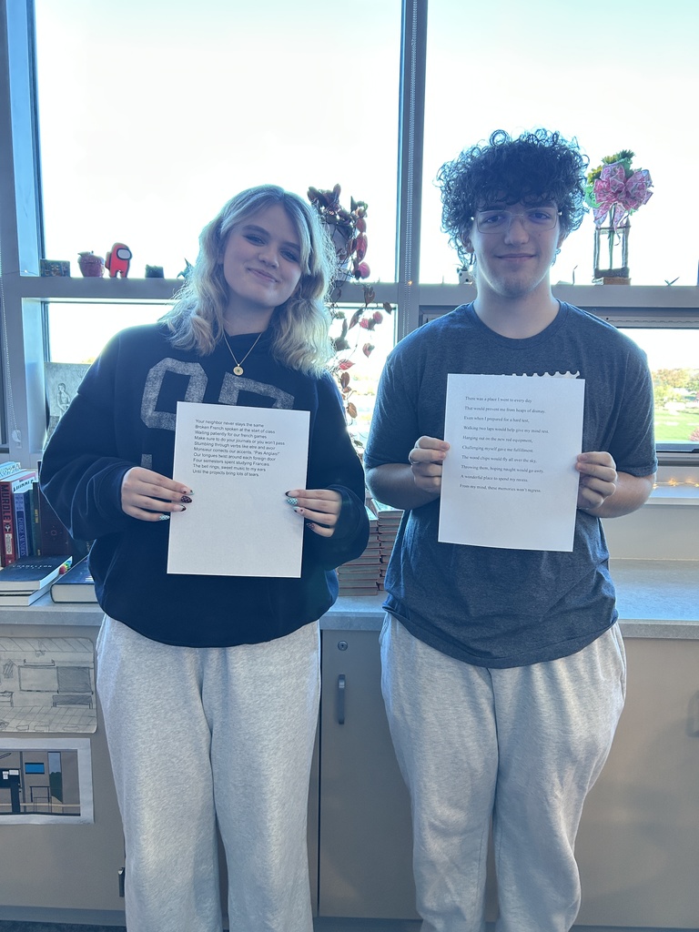 2 students holding up essays