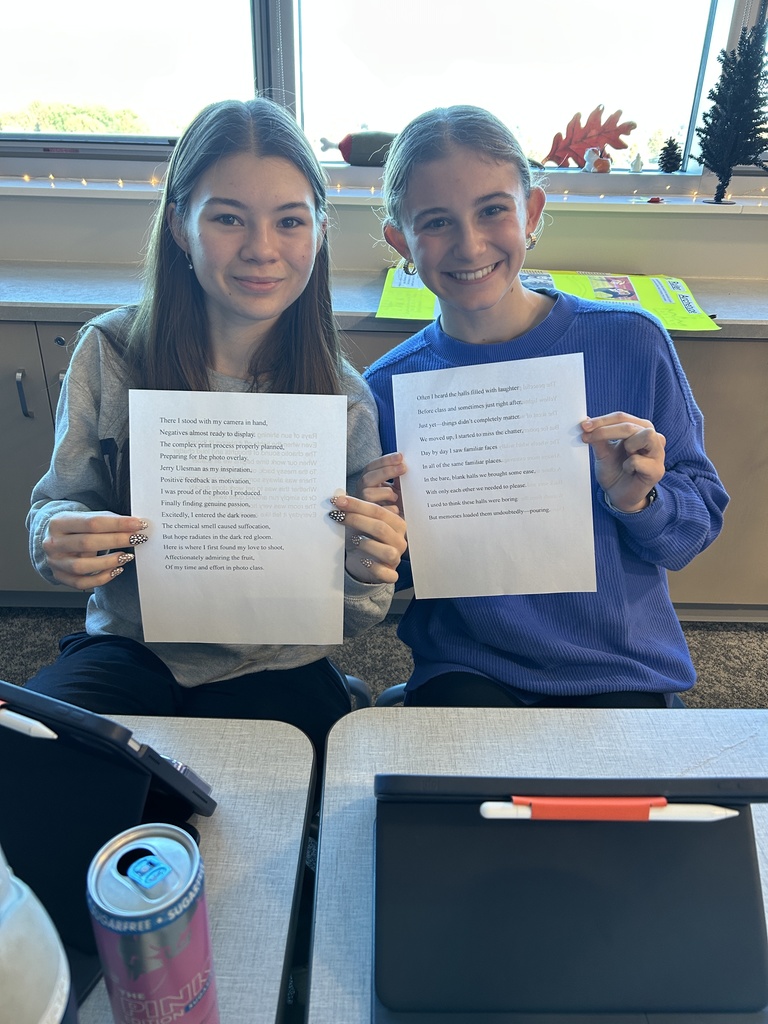 2 students holding up essays