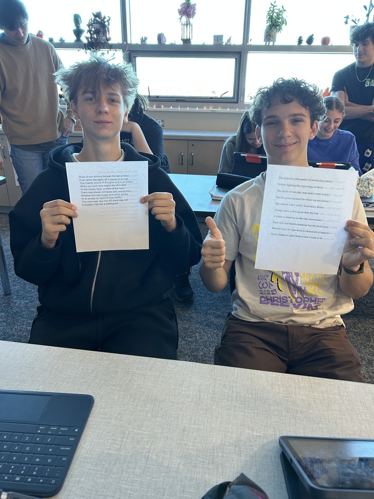 2 students holding up essays