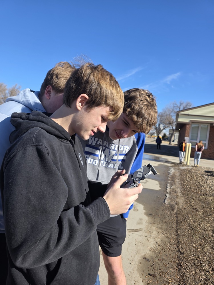 Lander Monson showing students how to fly the drone.