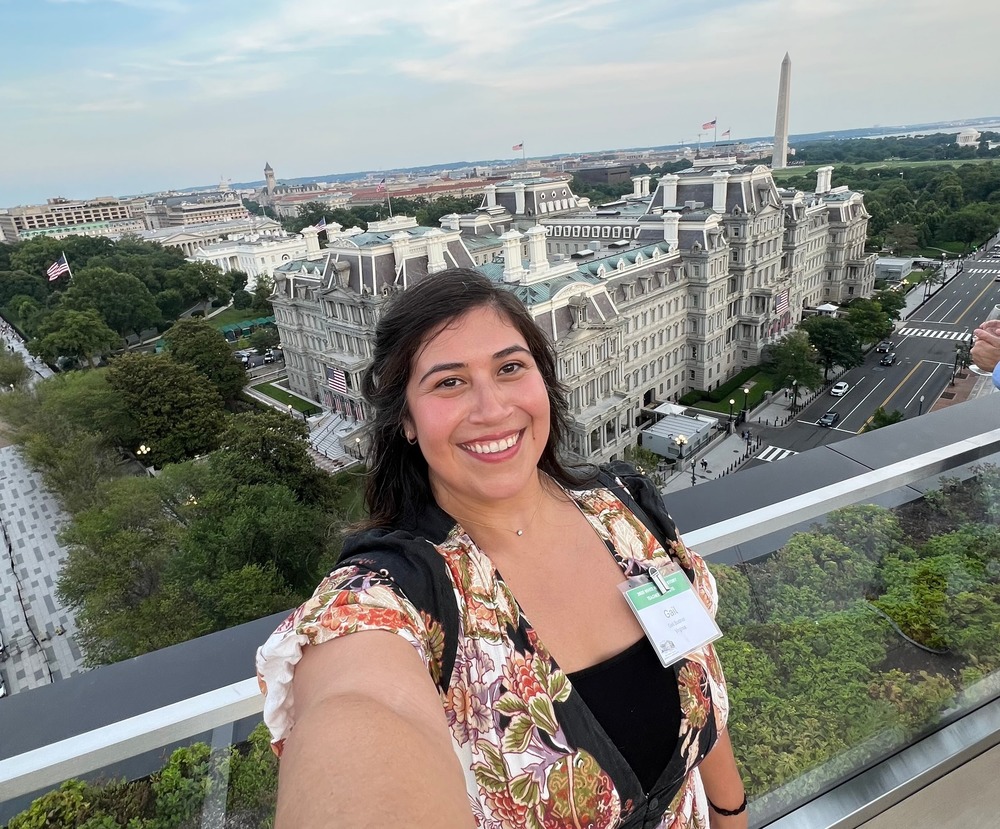 Teacher Gail Bodner with a selfie of the Old Executive Office Building and the White House behind her
