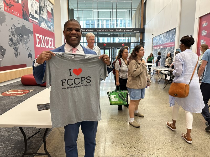 Terry Dade holding the new I love FCCPS t-shirt