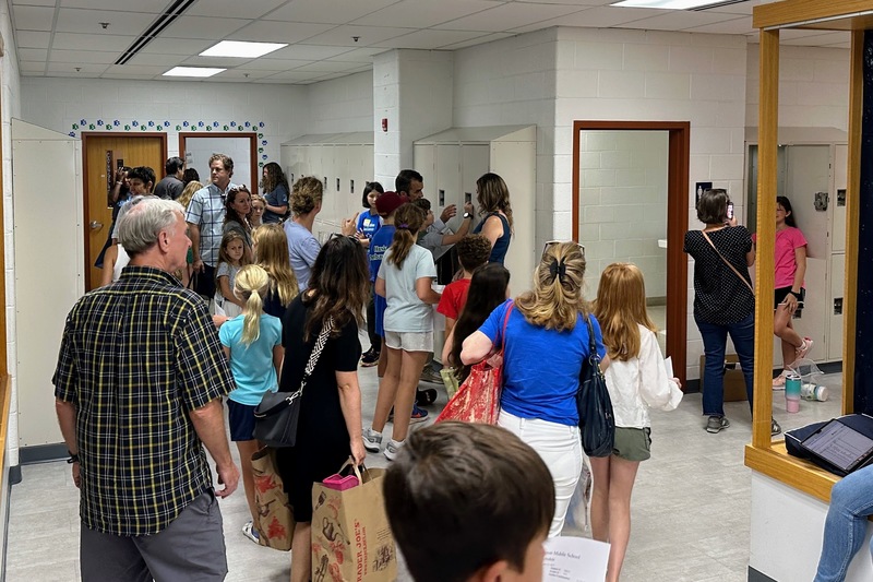 Many families in the locker hallway.