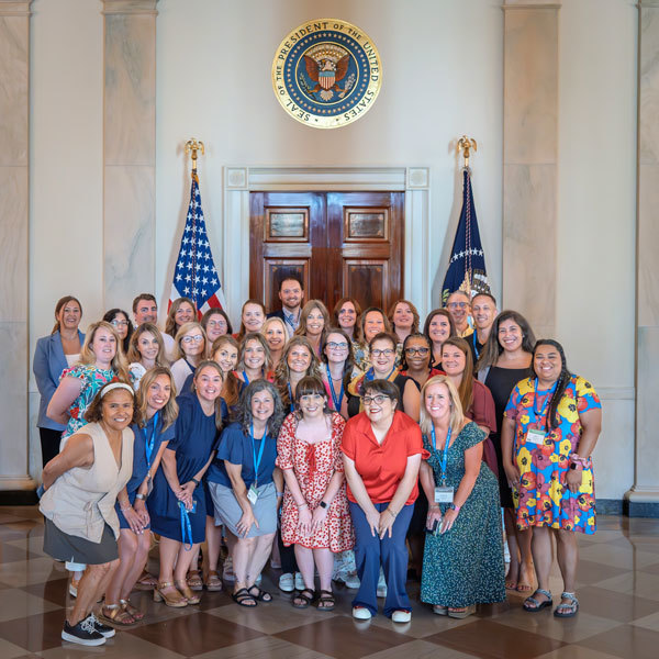 Gail Bodner and other Institute  attendees posing in front of the White House Door