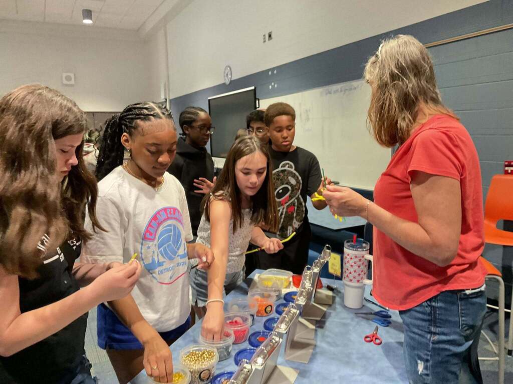 Students line up at a table demonstration in STEM class.